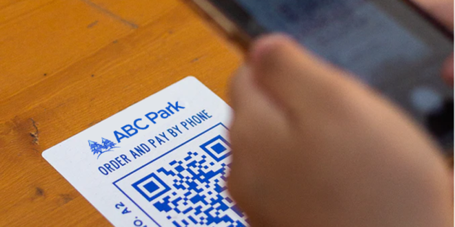 How do amusement parks maintain a touchless park experience with QR codes?